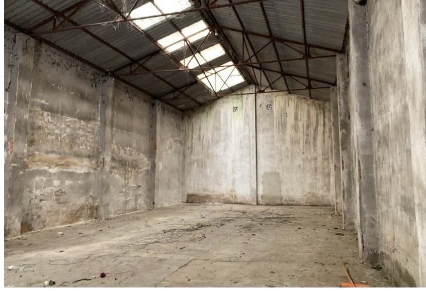 An empty industrial hall with a corrugated roof and skylights